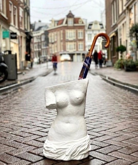 Classical sculpture torso on a European cobblestone street